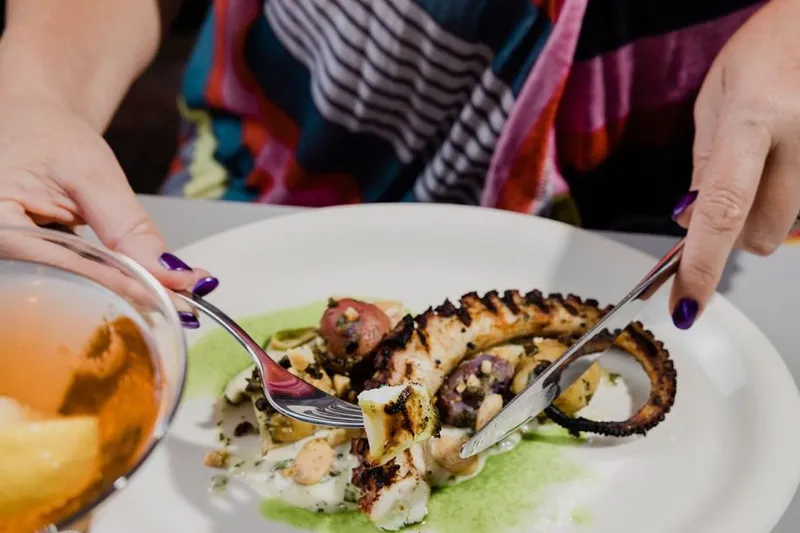 Grilled octopus plated with sauce at Grace