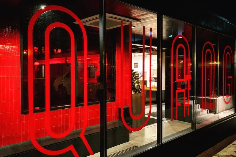 Nighttime storefront of Quang Restaurant at 2719 Nicollet Ave, Minneapolis, with large red QUANG lettering across the windows