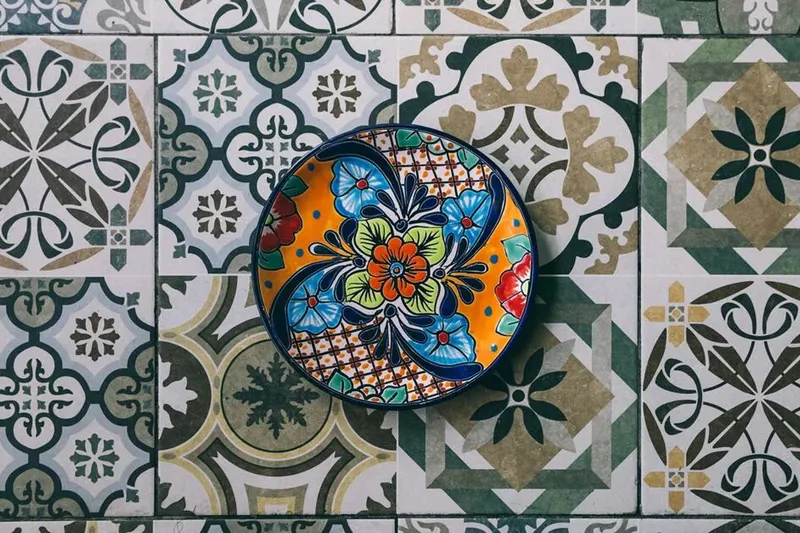 Decorative plate set on patterned tile at Mi Tocaya Antojería
