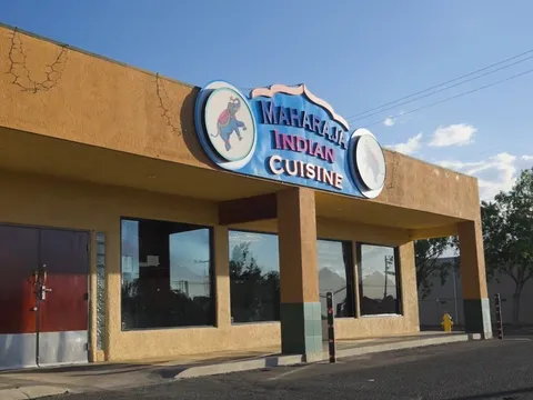 Adobe-colored exterior of Maharaja Indian Cuisine on Lomas Boulevard, with its elephant sign above the entrance