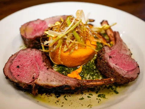 Sliced roasted rack of lamb with sweet potato and herb oil at Triple George Grill