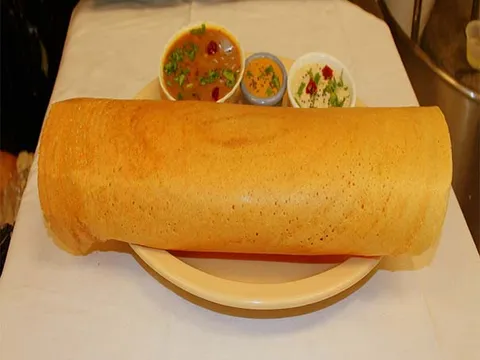 A large paper dosa served with sambar and two chutneys at Sri Dosa Place in Iselin.