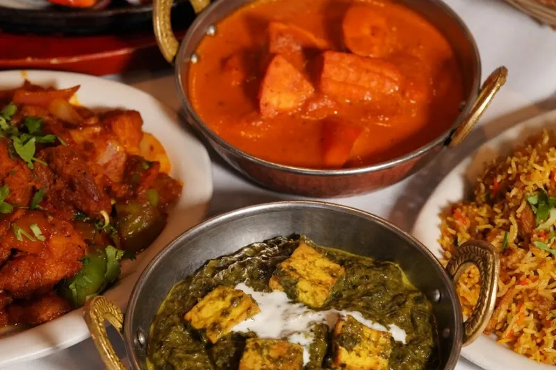 Curries, saag paneer and biryani in copper serving bowls at Mt. Everest