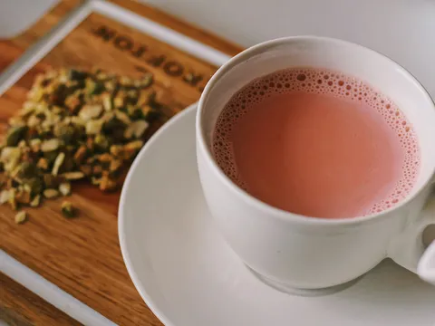Signature Kashmiri chai (pink tea) topped with nuts, served in a cup at Chai Shai Hillcroft