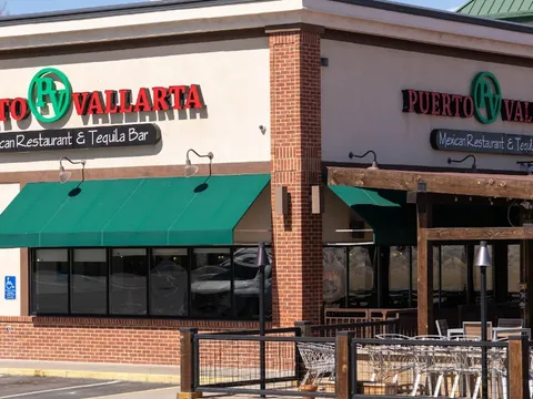 Exterior of Puerto Vallarta Mexican Restaurant & Tequila Bar with green awnings over the patio