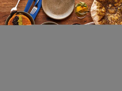 Spread of salatim, hummus, laffa, and lamb shoulder at Zahav