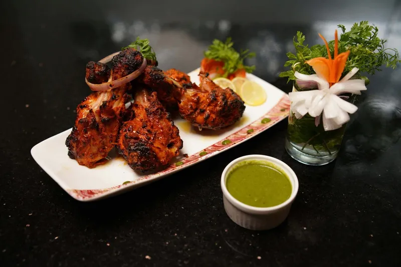 Platter of tandoori chicken with green chutney at Kabab and Curry