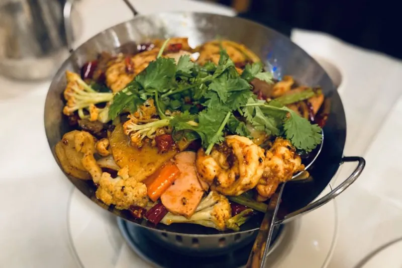 A sizzling griddled hot-and-spicy pot with chicken, cauliflower and dried chilies at Legend of Taste
