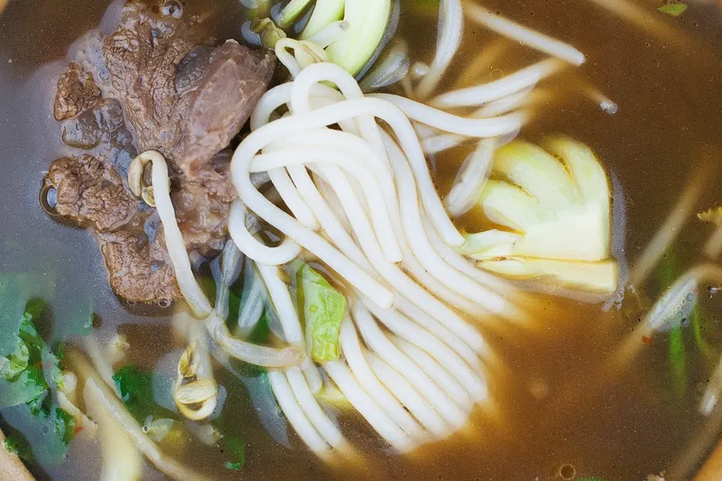 Bowl of beef and noodle soup with greens at Jade Garden