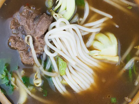 Bowl of beef and noodle soup with greens at Jade Garden