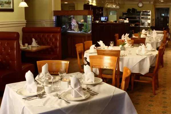Dining room at Great Taste in New Britain with white-linen tables, red leather booths, and a built-in aquarium