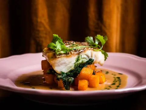 Grilled fish with greens and orange vegetables at Dakar NOLA