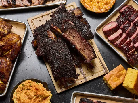 Spread of smoked ribs, brisket, chicken, and cornbread at Bludso's Bar & Que