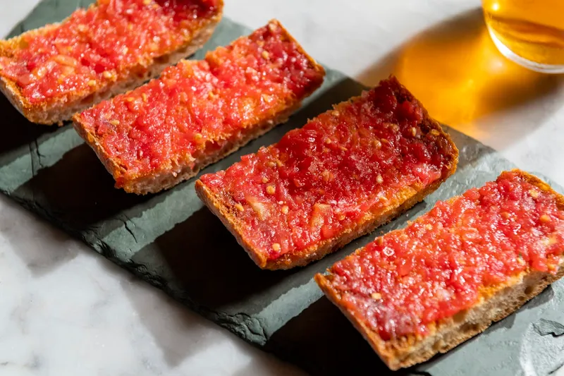 Pan con tomate on a slate board at Cúrate Bar de Tapas