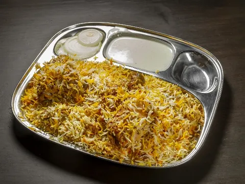 Chicken biryani served on a steel thali plate at Ghareeb Nawaz