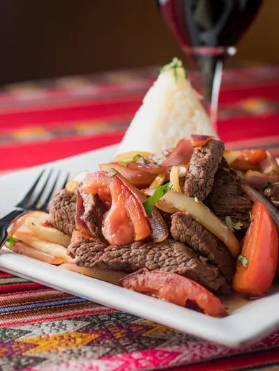 Lomo saltado (beef, onions and tomatoes) with white rice and a glass of red wine at Inca's Peruvian Cuisine in Tucson