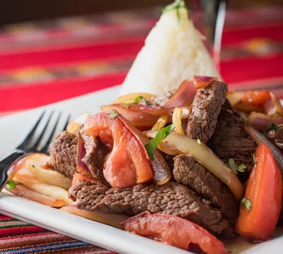 Lomo saltado (beef, onions and tomatoes) with white rice and a glass of red wine at Inca's Peruvian Cuisine in Tucson