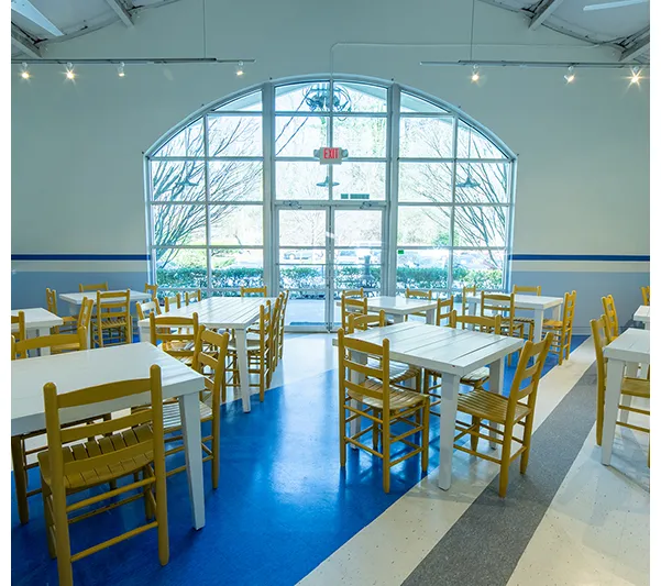 Bright dining room with yellow chairs and blue-and-white floors at Taqueria del Sol