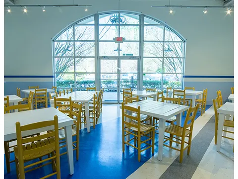 Bright dining room with yellow chairs and blue-and-white floors at Taqueria del Sol