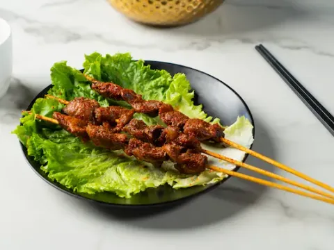 Grilled skewers on a bed of lettuce at Changsha Rice Noodle