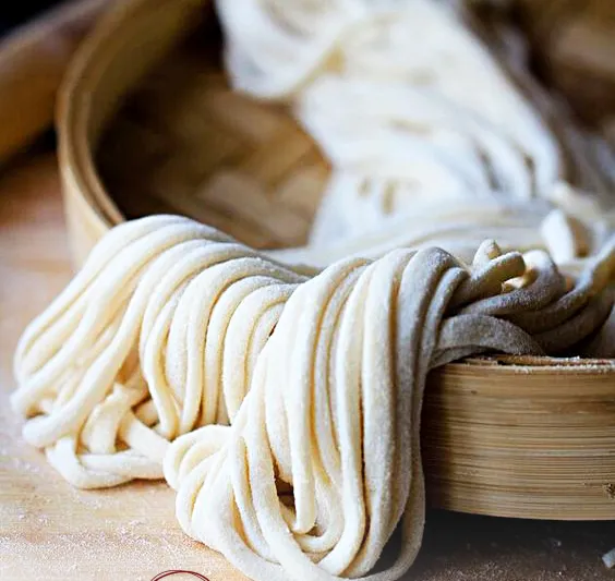 Hand-pulled noodles coiled in a bamboo steamer at Shang Artisan Noodle