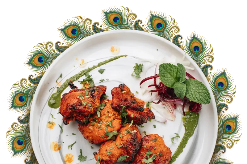 Tandoori chicken plated on a peacock-feather-rimmed dish at Peacock Indian Bar & Grill