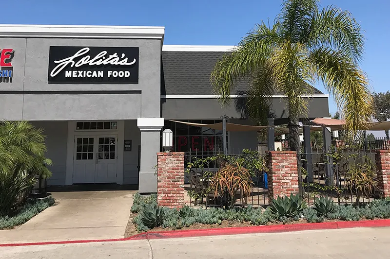 Lolita's Mexican Food storefront with black sign and gated brick patio at the Kearny Mesa location in San Diego