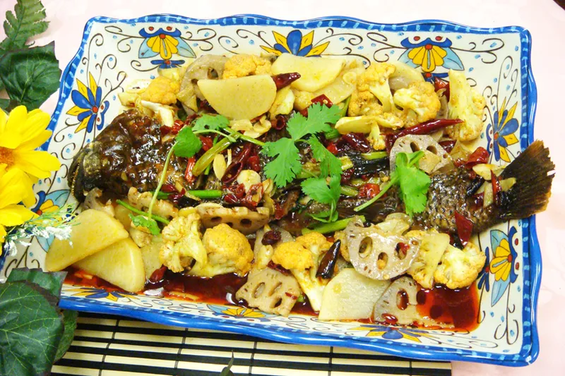 Chongqing roasted fish with lotus root, cauliflower and dried chilies on a decorative platter at Spicy City in San Diego