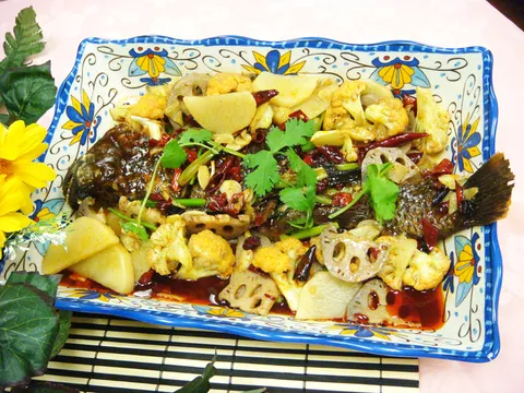 Chongqing roasted fish with lotus root, cauliflower and dried chilies on a decorative platter at Spicy City in San Diego