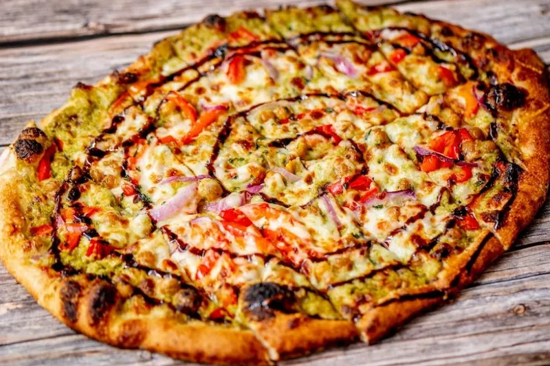 Wood-fired flatbread pizza with tomato, onion and herbs at American Flatbread Burlington Hearth