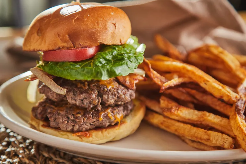 Double burger with lettuce and tomato served with hand-cut fries at The Brick