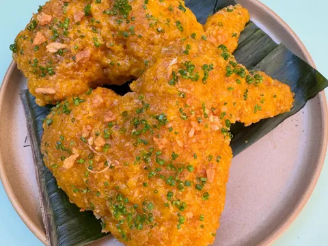Golden fried chicken pieces served on a banana leaf and stoneware plate at Lasita