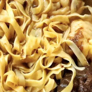Bowl of hand-cut egg noodles with beef brisket in broth at Mike's Noodle House