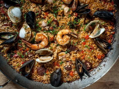 Pan of seafood paella with shrimp, clams, mussels and chorizo over saffron rice at Toro in Boston