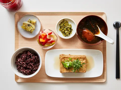 Overhead view of Yang's Kitchen tofu set meal with multigrain rice, miso soup, pickles, and small vegetable dishes