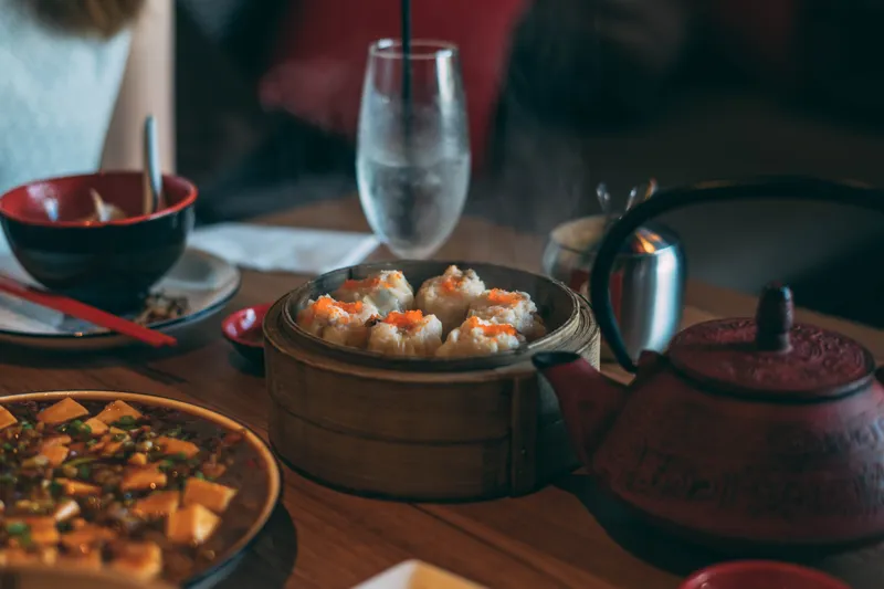 Dim sum steamer and mapo tofu on a table at Lai Hong Lounge