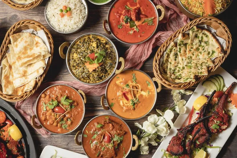 Table spread of curries, naan and grilled meats at Tandoori Grill