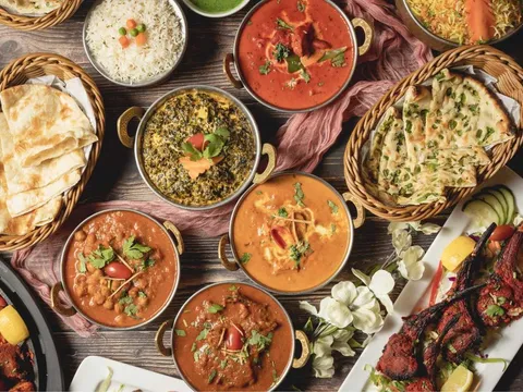 Table spread of curries, naan and grilled meats at Tandoori Grill