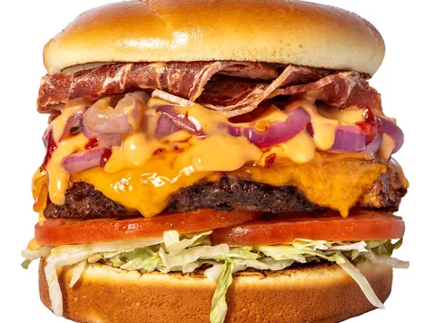 Slutty Vegan One Night Stand plant-based burger with vegan bacon, vegan cheese, onions, tomato, and lettuce on a bun