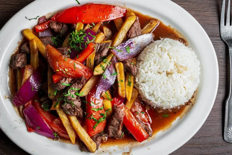 Lomo Saltado, sautéed beef with peppers, onions and french fries served with white rice, at Pio Pio