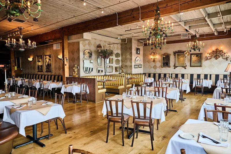 Bright dining room at The Pink Door with white tablecloths and chandeliers