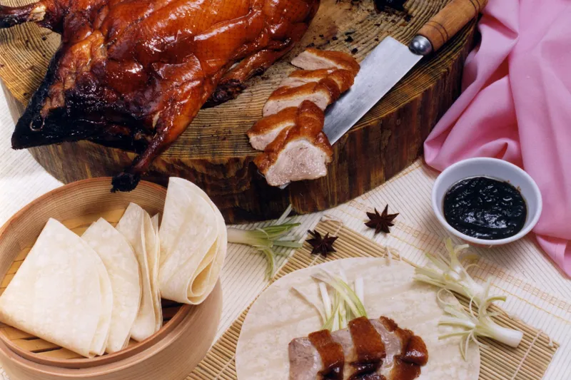 Whole roast Peking duck at Sang Kee, sliced, served with steamer pancakes, scallions and hoisin sauce