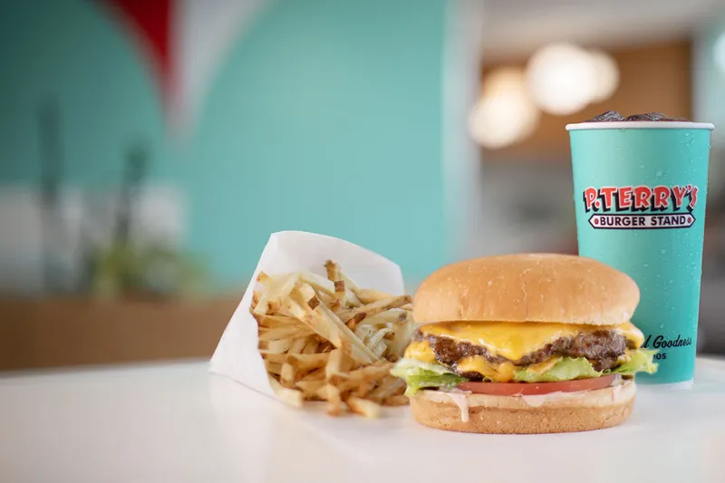 P. Terry's double cheeseburger, fresh-cut fries, and branded soft-drink cup on a restaurant table