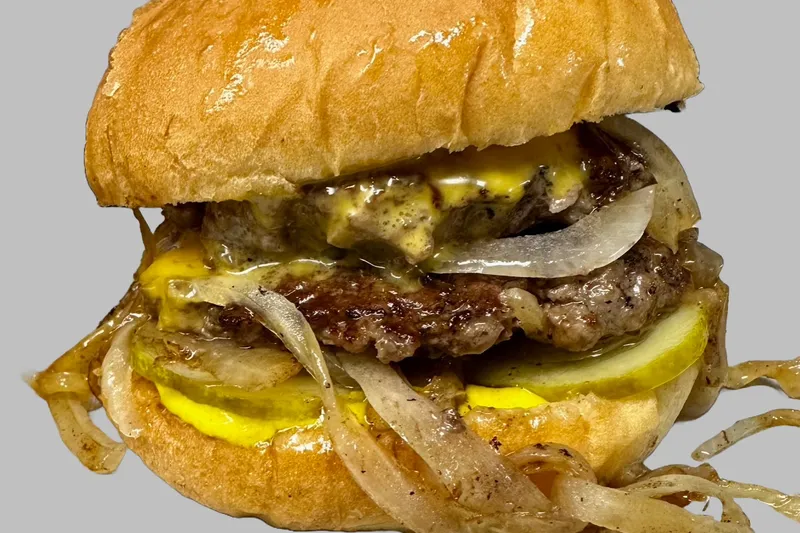 Motz's Burgers cheeseburger on a toasted bun with caramelized onions and pickles in Detroit