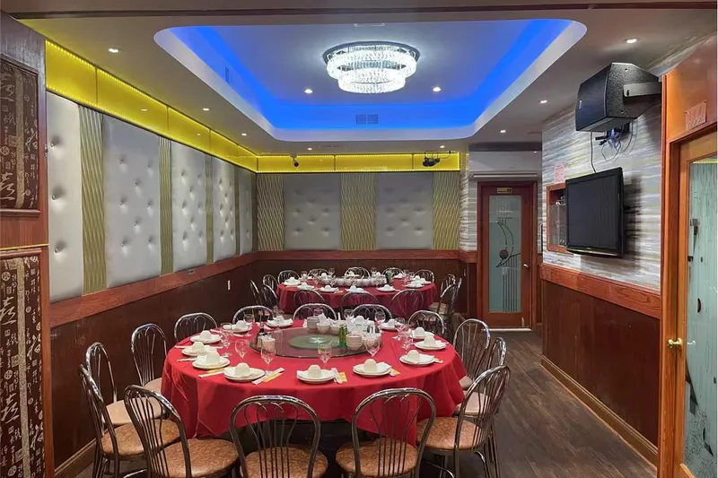 Interior banquet / VIP dining room at Tai Lake Seafood Restaurant in Philadelphia Chinatown, with round tables set under a crystal chandelier and blue cove lighting