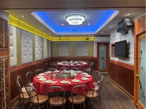 Interior banquet / VIP dining room at Tai Lake Seafood Restaurant in Philadelphia Chinatown, with round tables set under a crystal chandelier and blue cove lighting