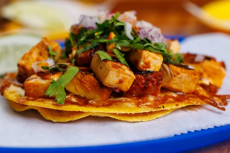 Del Trompo achiote pork taco with pineapple, cilantro and red onion on a crispy cheese-crusted tortilla at Mestiza
