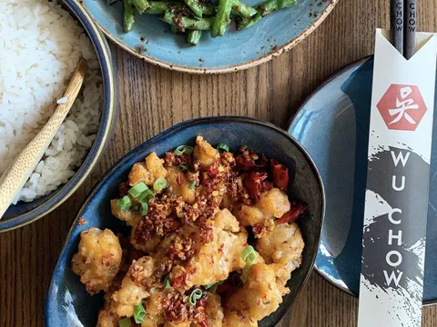 Chinese dishes and Wu Chow-branded chopsticks on a dining table