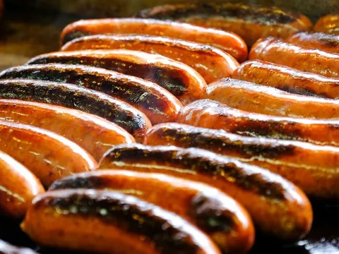 Grilled half-smoke sausages on the griddle at Ben's Chili Bowl
