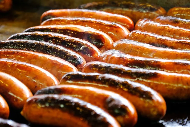 Grilled half-smoke sausages on the griddle at Ben's Chili Bowl